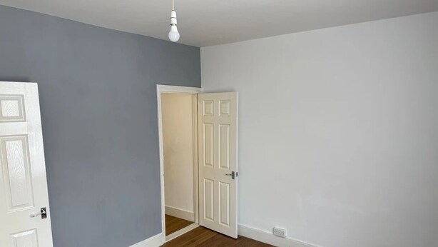 A room with a wooden floor, a white door, and a light switch on the wall. - Stunning Sea View Flat on The Leas Panoramic Estuary Sunsets, Steps to Beach (Sheerness)