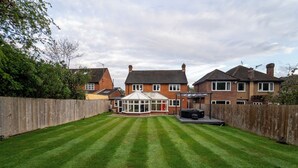 A well-maintained backyard with a lawn, a conservatory, and a barbecue area. - Stunning Sea View Flat on The Leas Panoramic Estuary Sunsets, Steps to Beach (Sheerness)