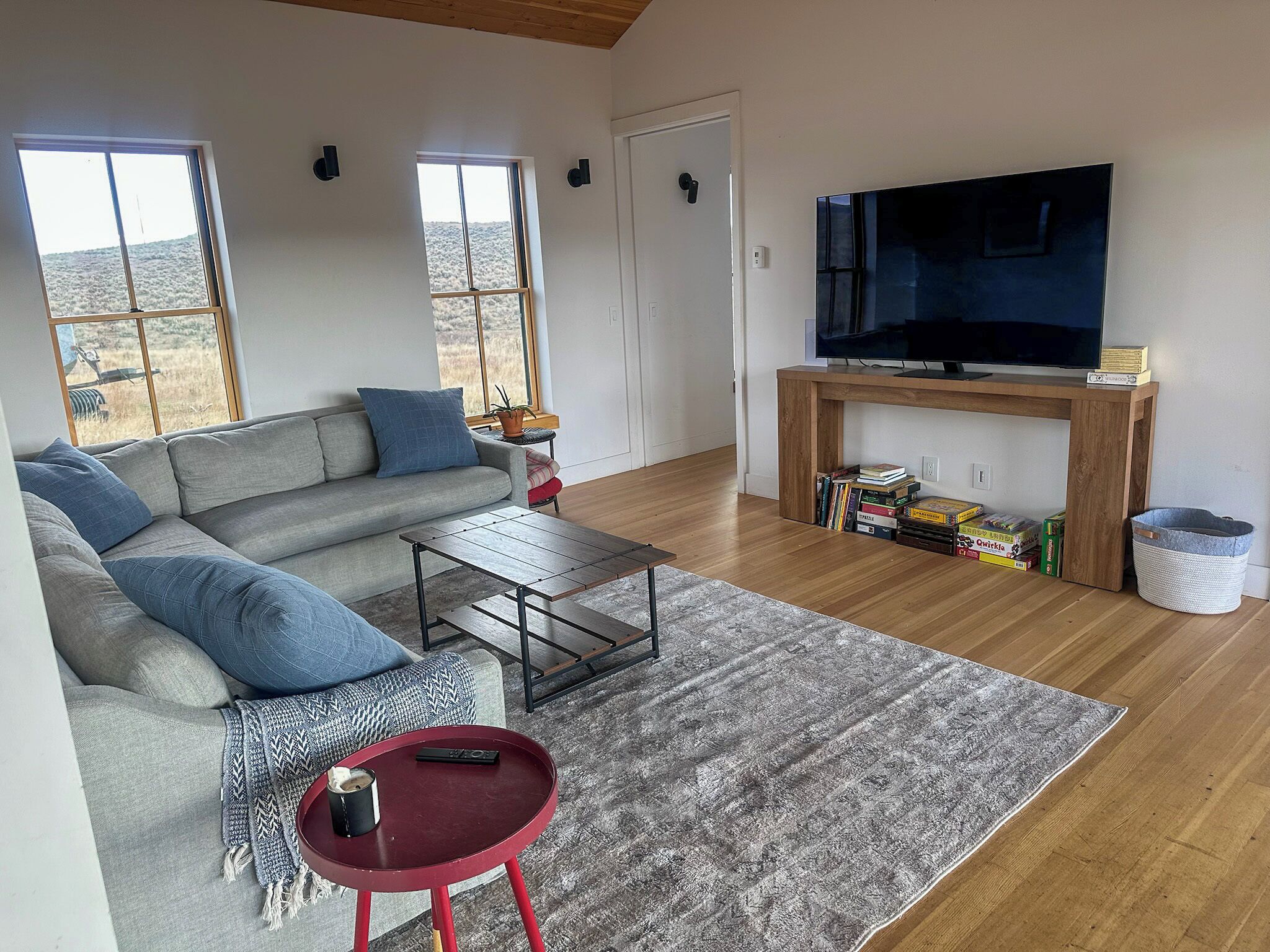 A living room with a sofa, a coffee table, a TV, and a fireplace.