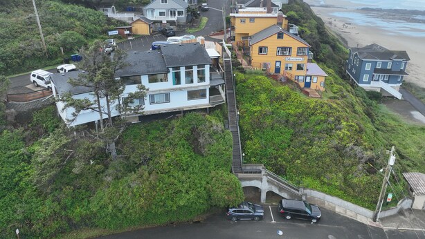Ein Küstenwohngebiet mit Häusern, einer Straße und einem Strand im Hintergrund.