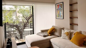 A modern living room with a sofa, a coffee table, and a painting on the wall. - Lovely 3 BDRM Apartment in Napoles, CDMX. (Ciudad de México)