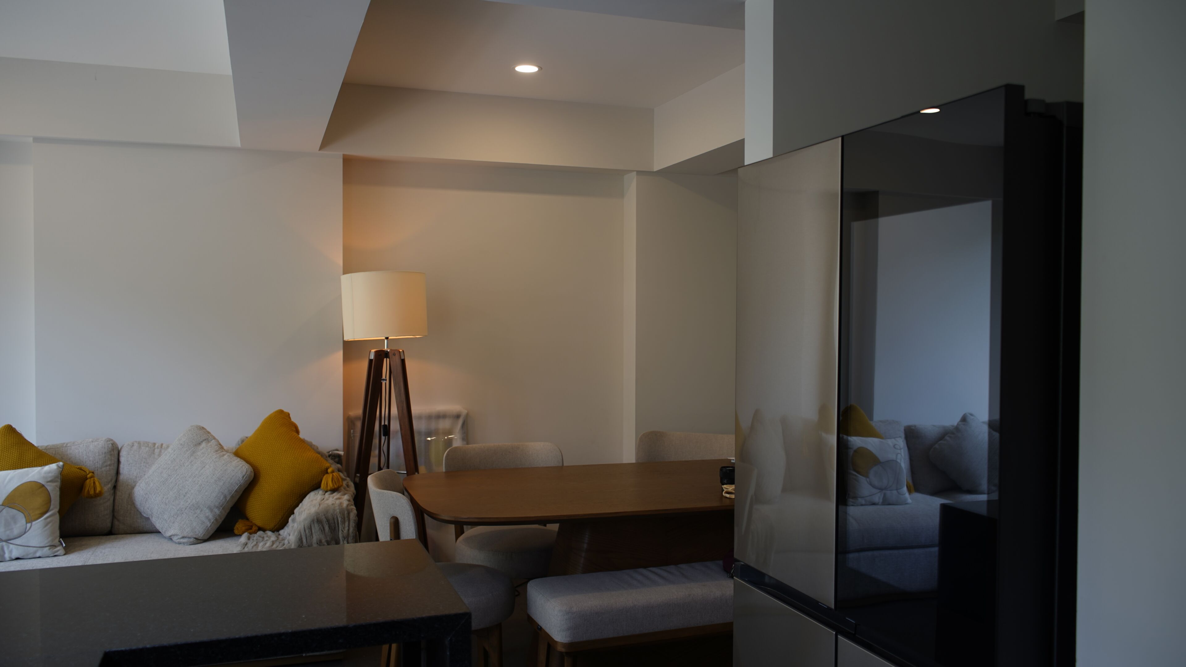 A modern living room with a sofa, a coffee table, and a dining table.