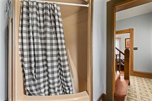 A bathroom with a shower curtain, a toilet, and a mirror.