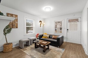 Ein Wohnzimmer mit einer Couch, einem Couchtisch und einer Zimmerpflanze.