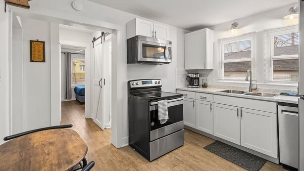 A modern kitchen with white cabinets, a stainless steel oven, a microwave, and a coffee maker. - Entire home in Concord, North Carolina, United States (Concord)