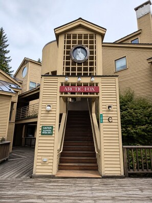A building with a sign reading 'ARCTIC-FOX' and a caution sign for slippery steps. - Mountain Basecamp Near Killington | Fireplace + Pool Access (Mendon)