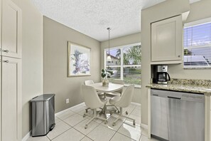 A compact kitchen with a dining area, a coffee maker, and a dishwasher. - NEW Island Living at Isla Del Sol | Ground Floor 2BR/2BA Getaway (Isla Del Sol)