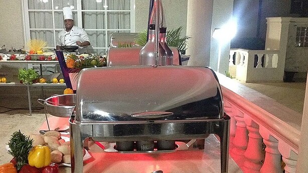 Een keuken met een grill, verschillende soorten fruit en groenten.