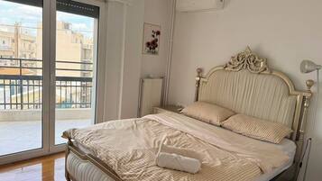 A bedroom with a bed, a radiator, a window, and a balcony.