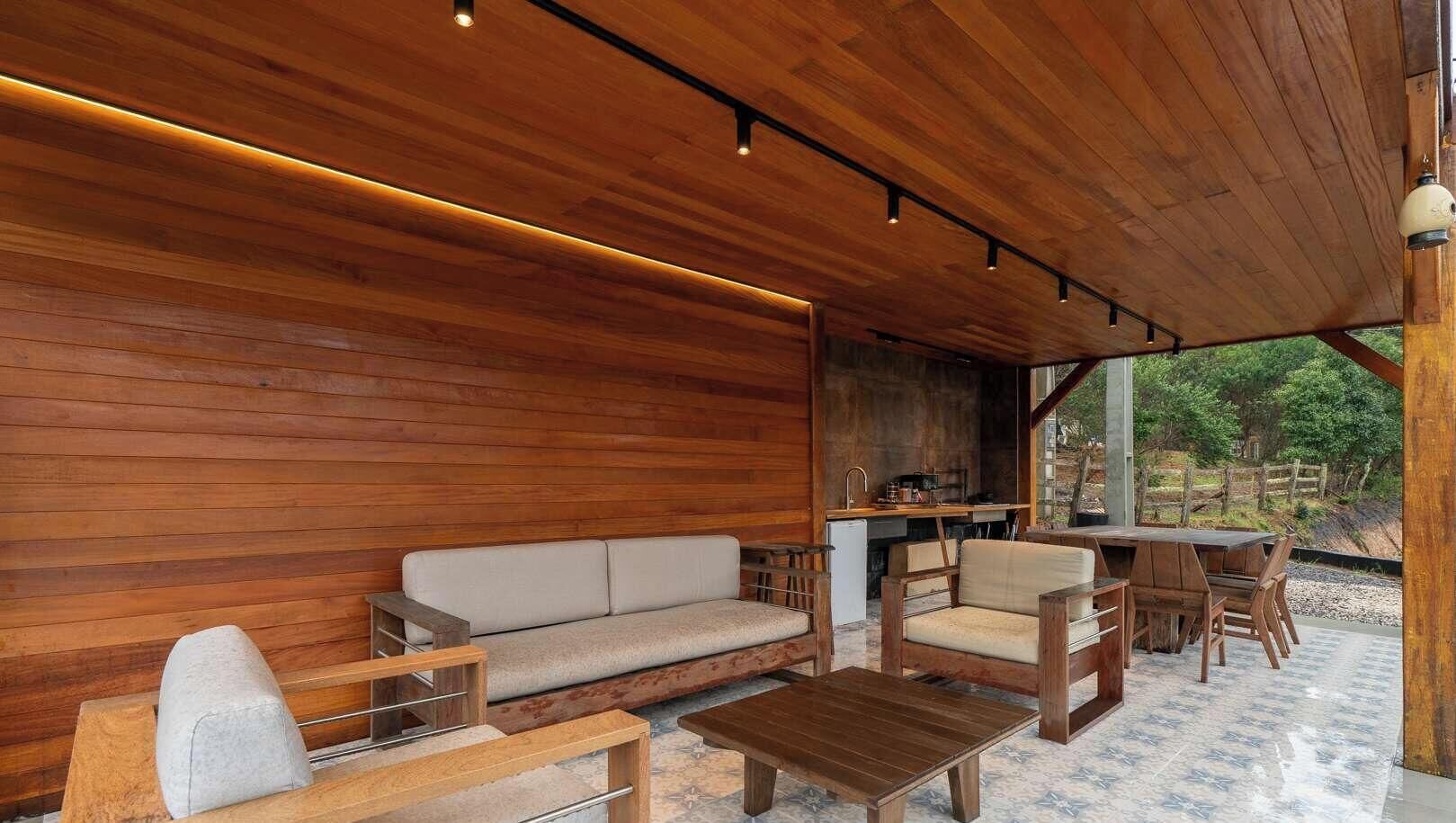 A wooden interior with a sofa, chairs, and a dining table.