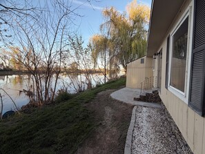 Ein Weg, der zu einem Haus mit Seeblick und Bäumen führt.