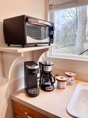 A kitchen with a built-in microwave, a coffee maker, and spice containers on the counter. - Private studio in Kenmore perfect for your relaxing getaway (Kenmore)