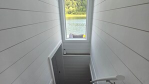 Eine Treppe mit Blick auf einen See und Wald durch ein Fenster.