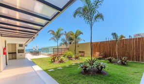 A modern outdoor area with a covered seating area, a pool, and a wooden fence. - Beachfront Apartment With Pool Cpk1009 (Ilhéus)