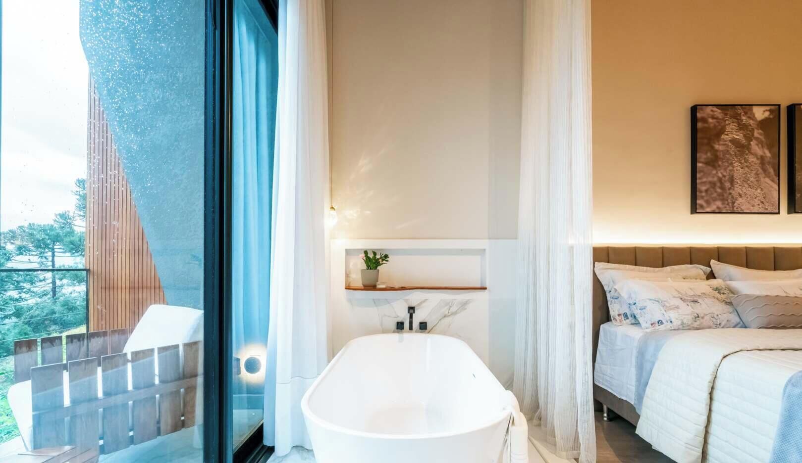 A modern bathroom with a freestanding bathtub, a shower area, and a bed with a headboard.