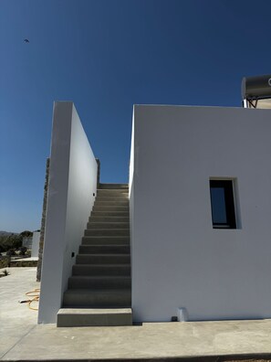 A staircase leading to a white building with a small window, under a clear blue sky. - Mister X Private Villa with Pool & 3 Bedrooms in Naxos (Naxos)
