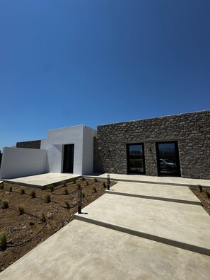Un edificio moderno con fachada de piedra y techo plano.