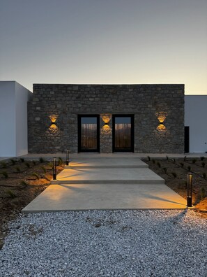 A modern building with a stone facade, two large doors, and a gravel pathway leading to the entrance. - Mister X Private Villa with Pool & 3 Bedrooms in Naxos (Naxos)
