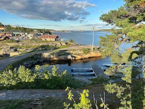 A coastal area with a dock, boats, and a small settlement with buildings.
