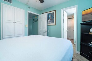 A bedroom with a bed, a door, a painting, and a television. - Coastal Bliss and Beachfront Resort Oasis for 5! (Panama City Beach)
