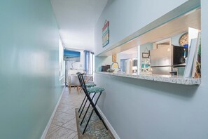 Una cocina con refrigerador, estufa y un reloj en la pared.