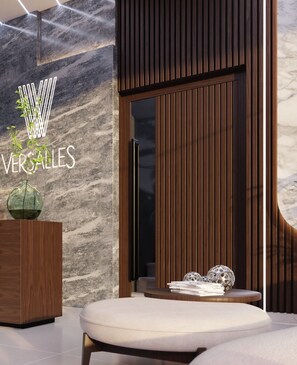 A modern interior with a marble wall, a wooden reception desk, a reception area, and a seating area. - Luxury Tower Apartment Near Monument  Pool & Balcony (Santiago de los Caballeros)