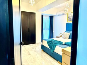 A bedroom with a bed, a nightstand, a dresser, a wardrobe, and a window with curtains. - Luxury Tower Apartment Near Monument  Pool & Balcony (Santiago de los Caballeros)