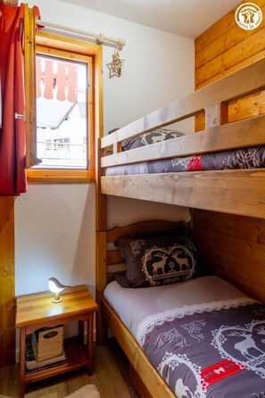A bunk bed with a window, a bedside table with a lamp, and a small shelf with books. - The Marmot of Aussois (AUSSOIS)