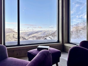 A room with large windows offering a view of a snow-covered landscape. - Mountain cabin in Ljosland with ski-in access (Åseral)