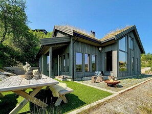 A modern wooden house with large windows and a covered patio area. - Mountain cabin in Ljosland with ski-in access (Åseral)