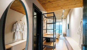A hotel room with a wooden ceiling, a large mirror, and a view of the mountains.