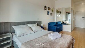 Ein modernes Hotelzimmer mit einem großen Bett, einem Schreibtisch, einem Stuhl und einem Spiegel.