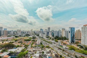 A cityscape with high-rise buildings, a bridge, and a highway. - Studio in Vila Cordeiro Ctb2505 (São Paulo)