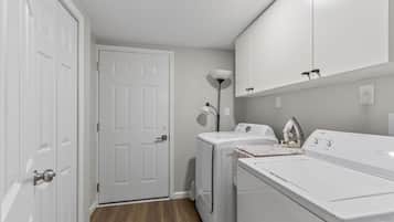A laundry room with a washing machine, dryer, and a door.