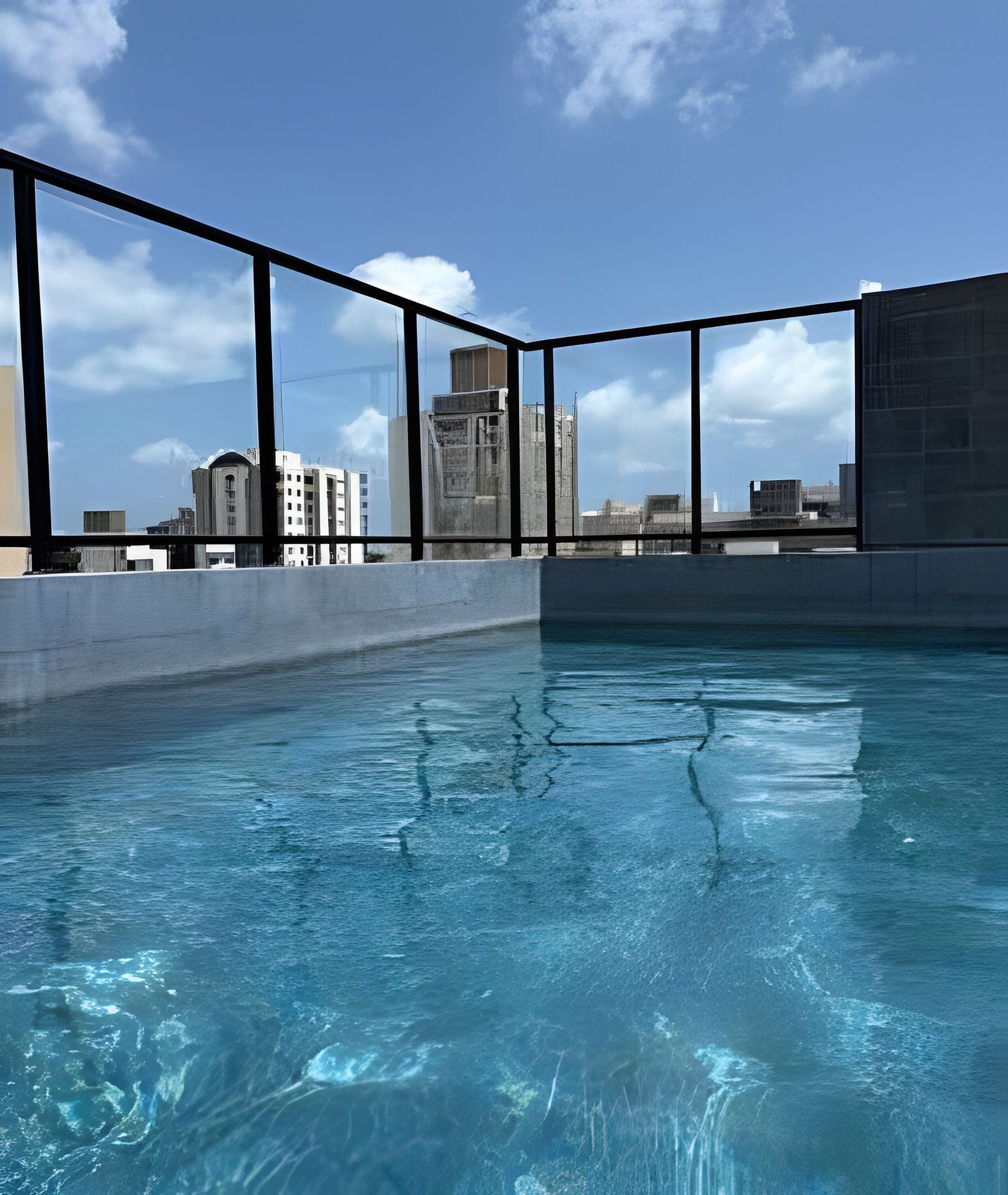 Ein Innenpool mit Blick auf die Stadt durch große Fenster.