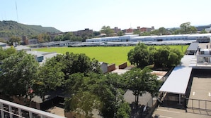 Un campo de deportes con un edificio al fondo.