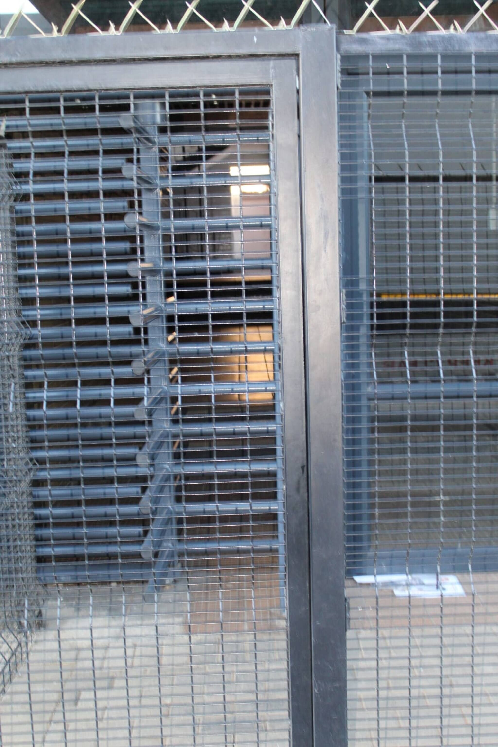 Una reja metálica con barras horizontales, probablemente dando acceso a un edificio o propiedad.