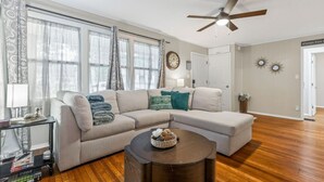 A living room with a sectional sofa, a round coffee table, and a ceiling fan. - 2Bdrm - 7 Minutes To Downtown (Kansas City)