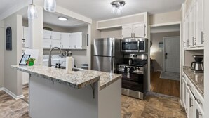 A modern kitchen with granite countertops, stainless steel appliances, and pendant lighting. - 2Bdrm - 7 Minutes To Downtown (Kansas City)
