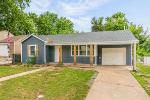 A residential house with a garage, a front porch, and a well-maintained lawn. - 2Bdrm - 7 Minutes To Downtown (Kansas City)
