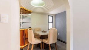 Un comedor compacto con una mesa redonda y dos sillas, una barra pequeña y una ventana.