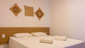A neatly made bed with white linens and rolled towels, a wooden headboard, and three woven wall hangings. - Nice Apart Near Patacho Beach Cvpa103 (Porto de Pedras)