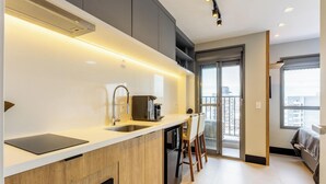 Eine moderne Küche mit Backofen, Spüle und Kaffeemaschine.