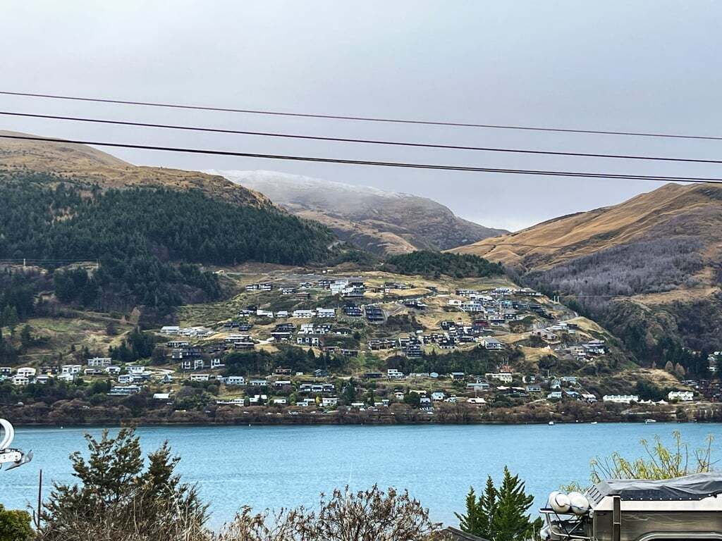 A residential area with houses on a hillside overlooking a body of water.