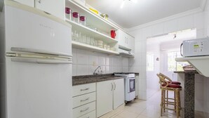 Una cocina con armarios blancos, estufa y refrigerador.
