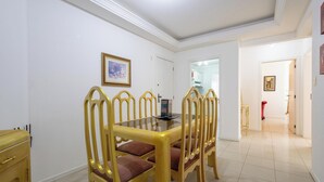 Un comedor con una mesa y sillas, una puerta que da a otra habitación y un cuadro en la pared.
