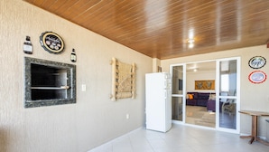 Una cocina moderna con horno empotrado, refrigerador y una botella de vino en la pared.