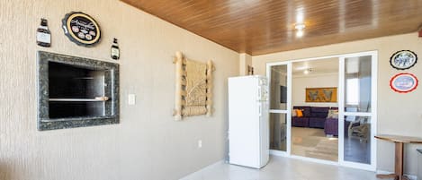 Una cocina moderna con horno empotrado, refrigerador y una botella de vino en la pared.