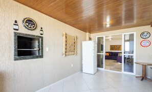 Una cocina moderna con horno empotrado, refrigerador y una botella de vino en la pared.