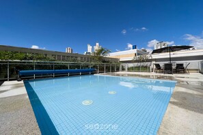 Piscina com paisagem urbana ao fundo.